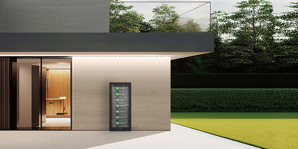 Electric vehicle charging station installed on the wall of a modern house with a blue car parked in front.